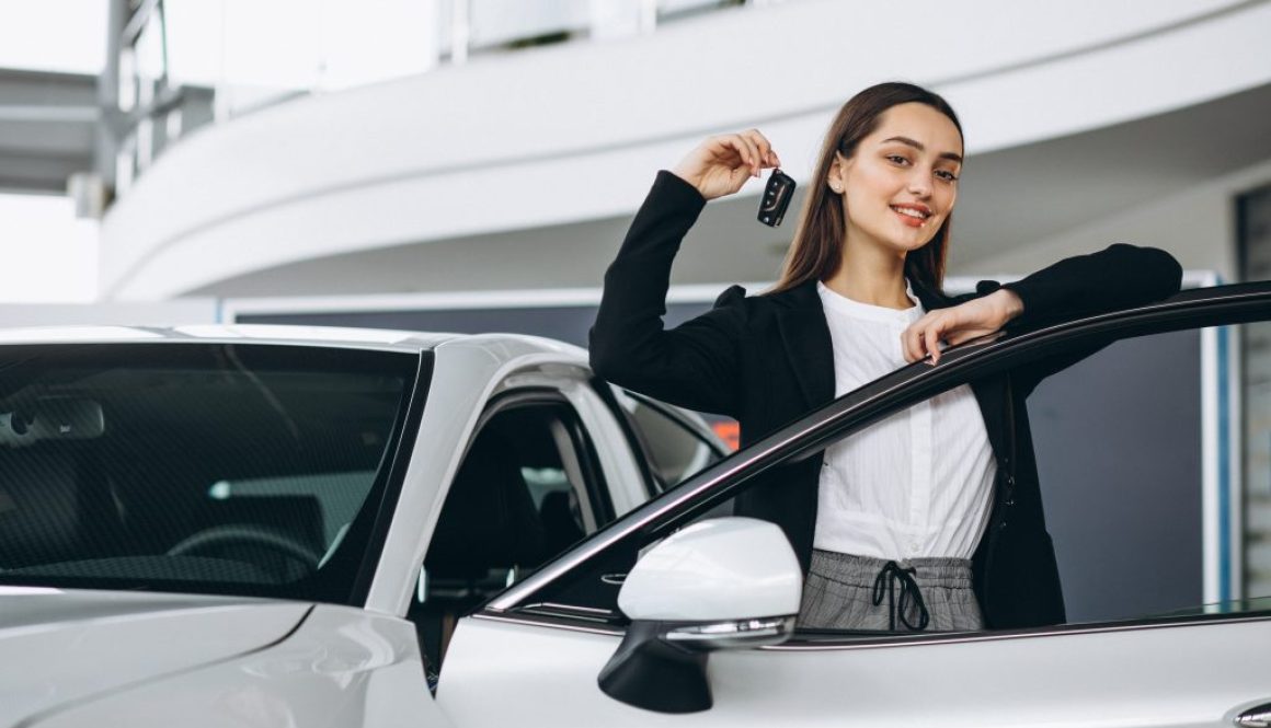 Woman choosing a car in a car showroom