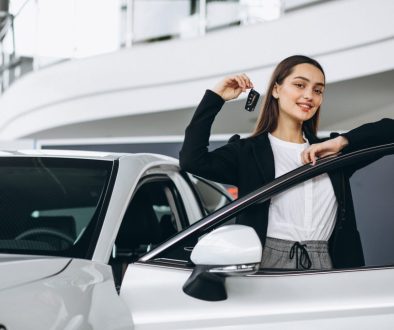 Woman choosing a car in a car showroom